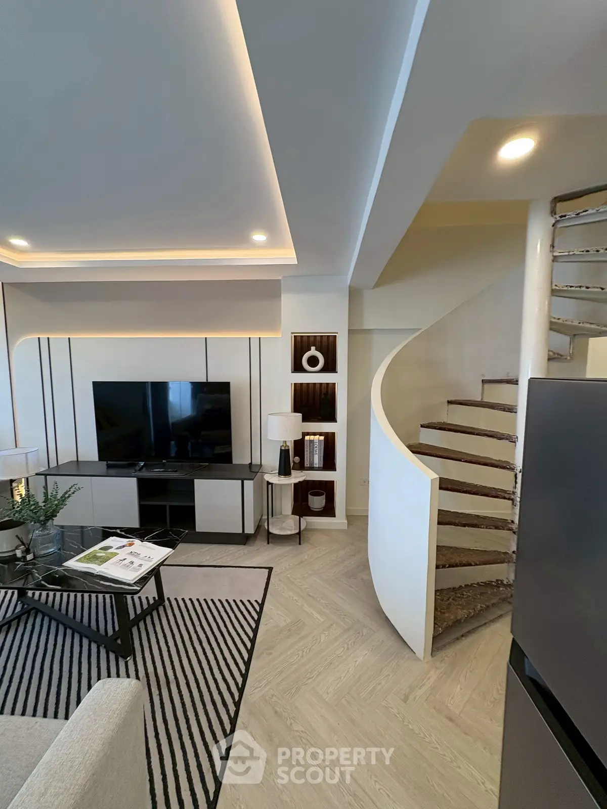 Modern living room with stylish spiral staircase and sleek TV setup
