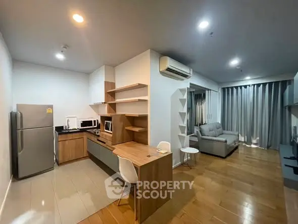 Modern open-layout kitchen and living room with sleek design and wooden flooring.