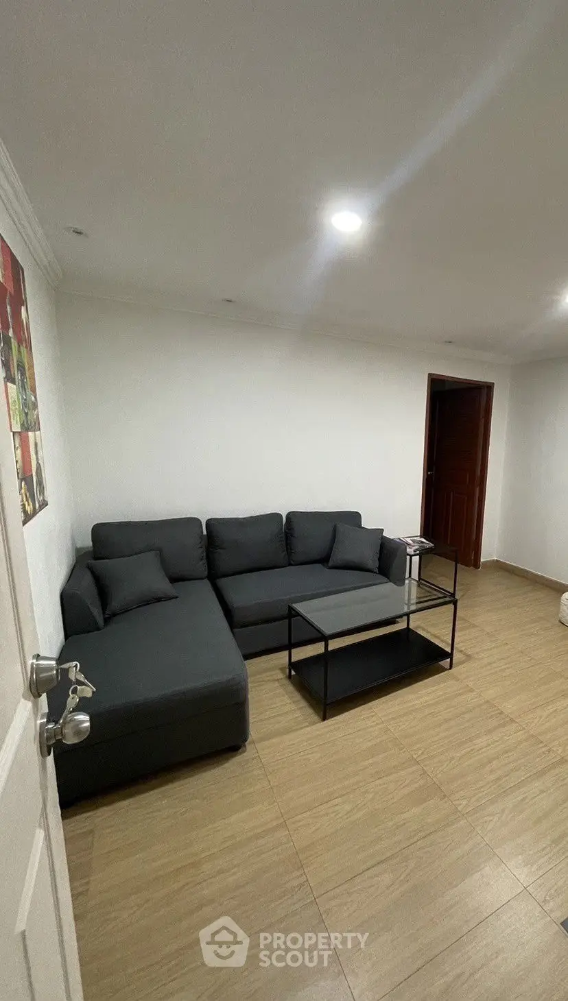 Modern living room with sleek gray sectional sofa and minimalist decor.