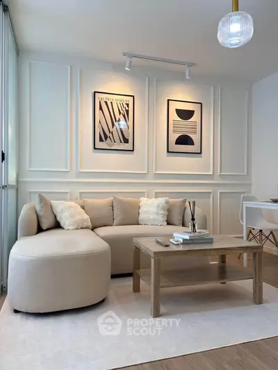Elegant living room with modern decor, featuring a cozy beige sofa and stylish wall art, perfect for relaxation.
