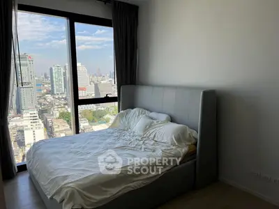 Modern bedroom with city view and large window in high-rise apartment