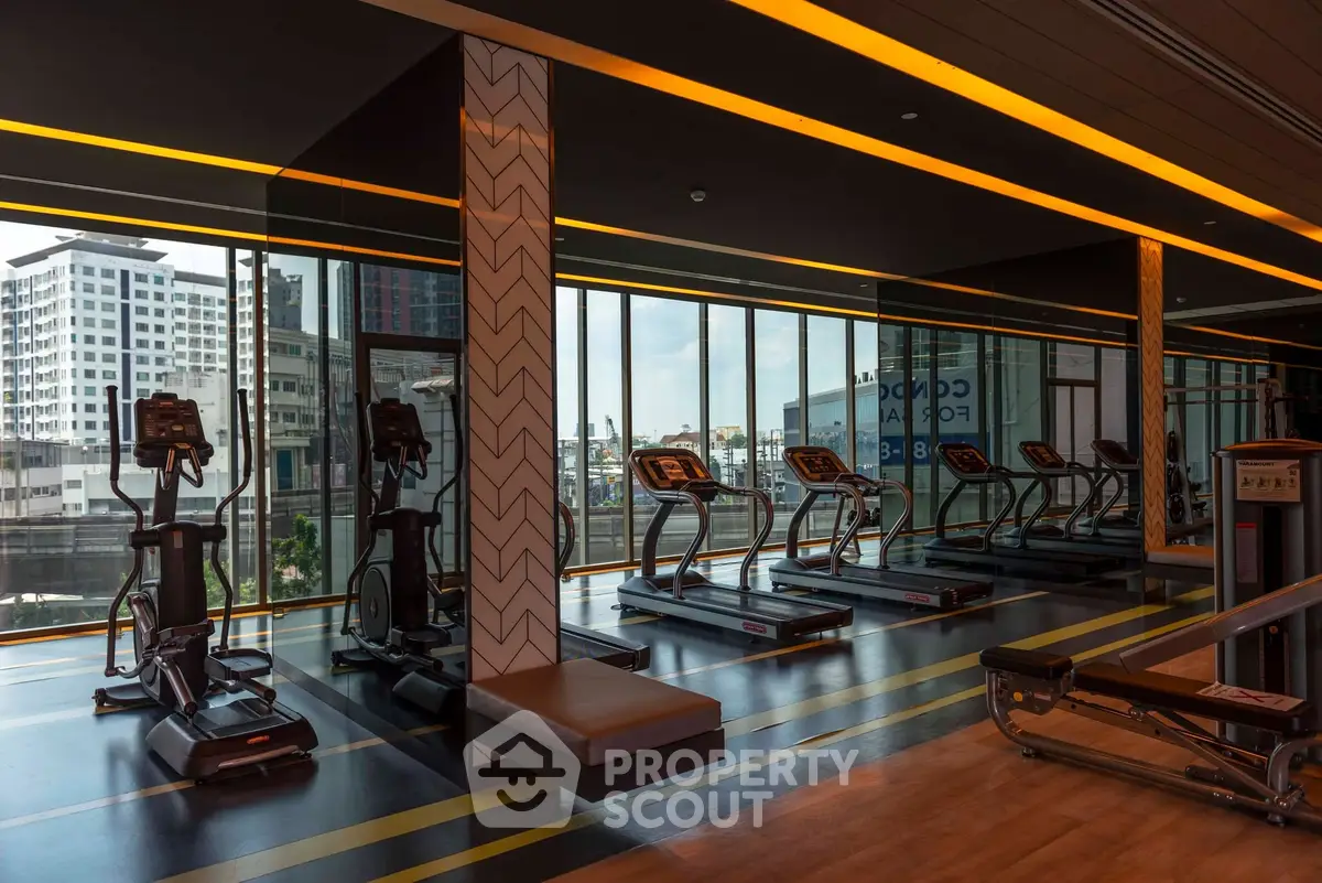 Modern gym with treadmills and city view in luxury apartment building