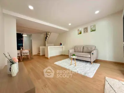 Modern living room with stylish decor and open layout, featuring cozy seating and elegant dining area.