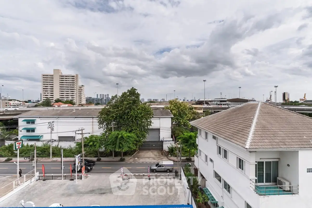 Urban landscape view with residential and commercial buildings under a cloudy sky.