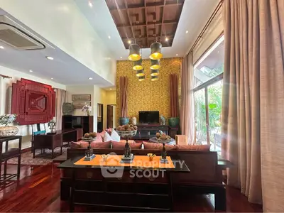 Luxurious living room with elegant decor and large windows offering garden views.