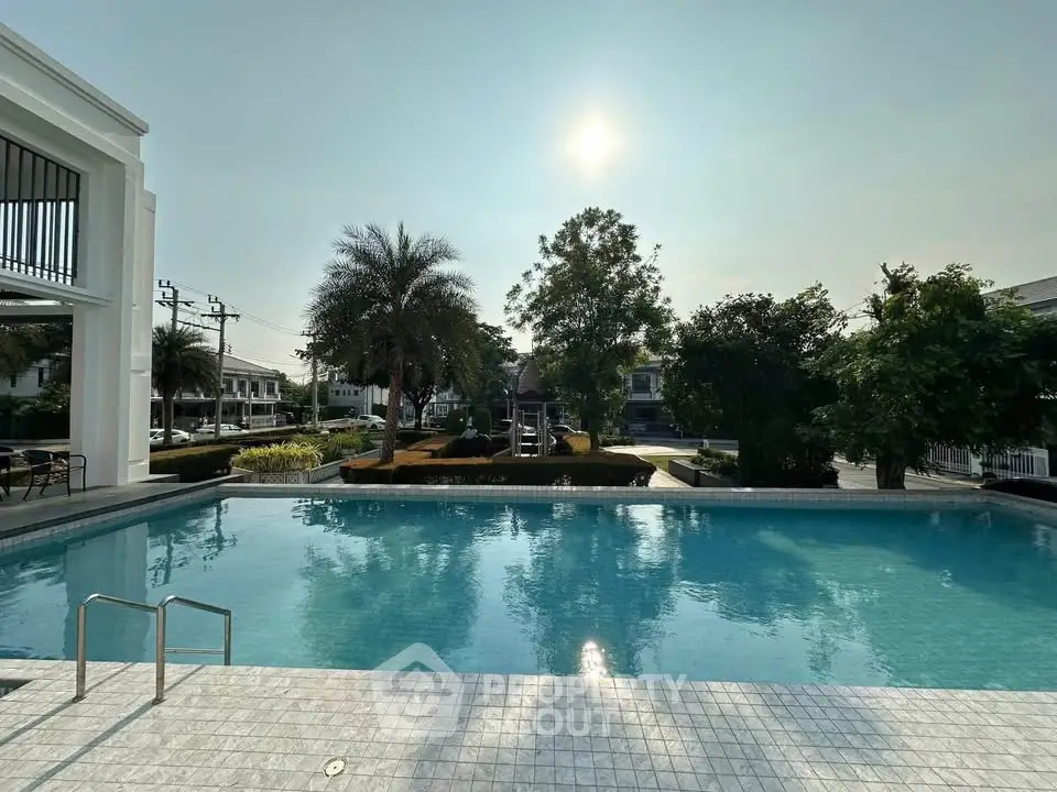 Luxurious residential pool with serene surroundings and lush greenery