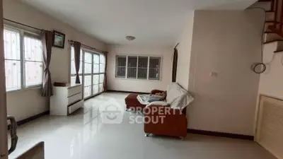 Spacious living room with large windows and cozy seating area