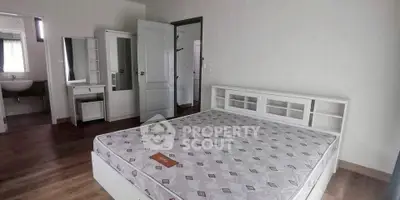 Spacious bedroom with modern furnishings and ensuite bathroom in a stylish home.