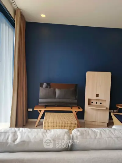 Modern living room with stylish furniture and blue accent wall