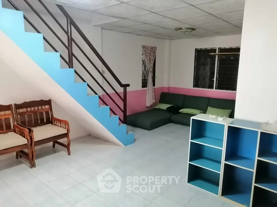 Spacious living room with modern staircase and cozy seating area.