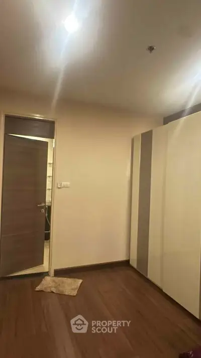 Spacious bedroom with modern wardrobe and wooden flooring