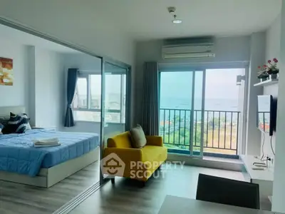Modern apartment with ocean view, featuring a cozy living room and bedroom with large windows.