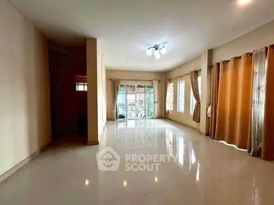 Spacious living room with large windows and elegant curtains