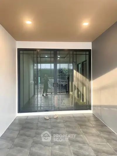 Modern balcony with sliding glass doors and tiled flooring