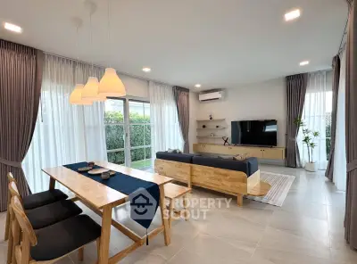 Spacious modern living room with elegant dining area and garden view, perfect for family gatherings.