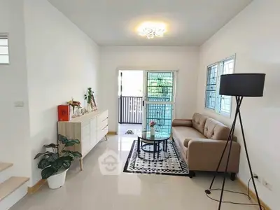 Modern living room with cozy sofa and stylish decor, featuring a bright and airy ambiance.