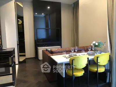 Modern living room with stylish dining area and large TV, featuring elegant decor and cozy ambiance.