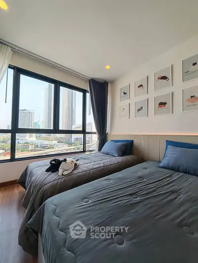 Modern bedroom with twin beds and city view, featuring stylish decor and large windows for natural light.