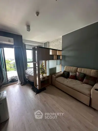 Modern living room with stylish partition and cozy sofa, featuring a balcony with a scenic view.