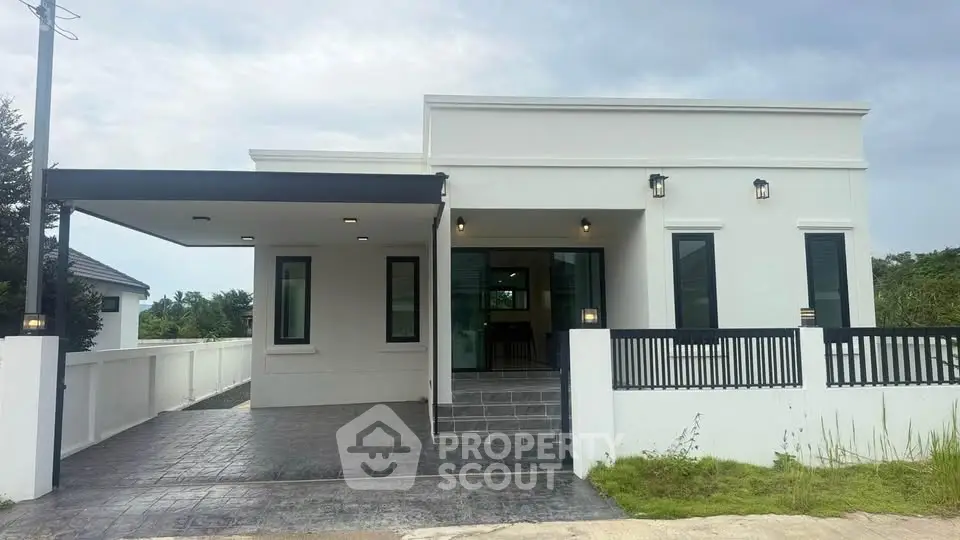 Modern single-story white house with sleek design and spacious driveway