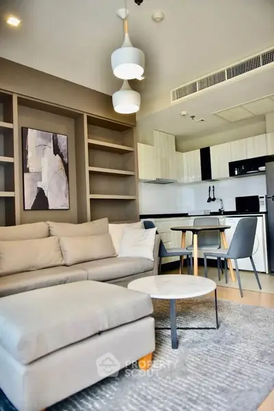 Modern living room with open kitchen, stylish decor, and cozy seating in a contemporary apartment.