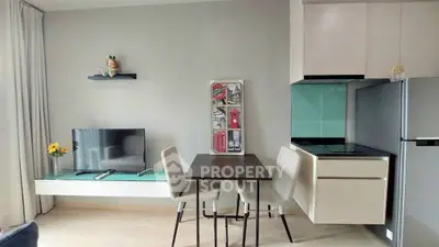 Modern living room with sleek furniture and stylish decor, featuring a mounted TV and compact dining area.