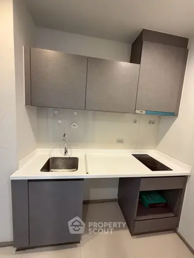 Modern compact kitchen with sleek cabinetry and built-in electric stove