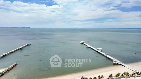 Stunning beachfront view with piers extending into the ocean under a clear blue sky.