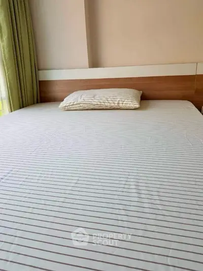 Spacious bedroom with a large bed and natural light from window