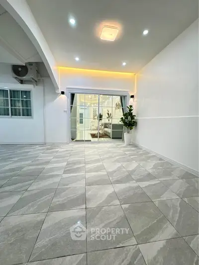 Spacious modern living room with elegant tile flooring and ambient lighting