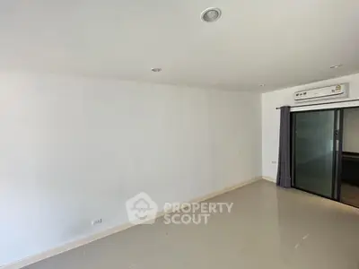 Spacious unfurnished room with air conditioning and sliding glass doors