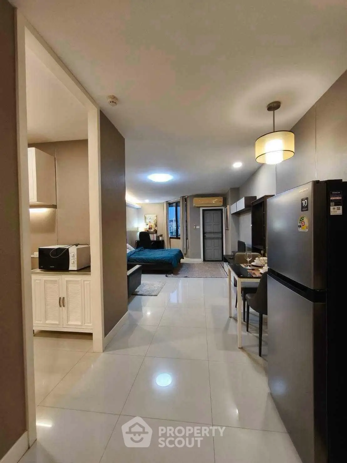 Modern open-plan apartment with sleek kitchen and cozy living area, perfect for urban living.