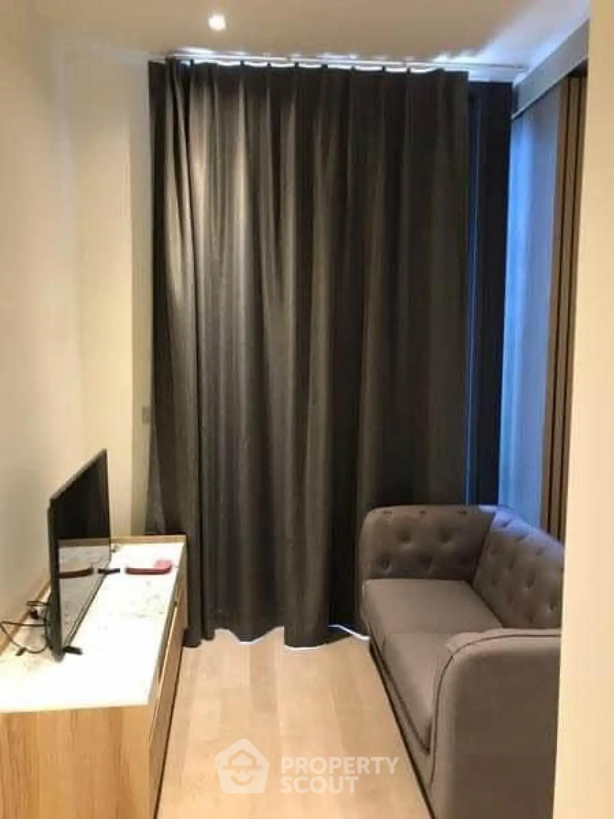 Cozy small living room with modern sofa and TV, ideal for compact spaces.