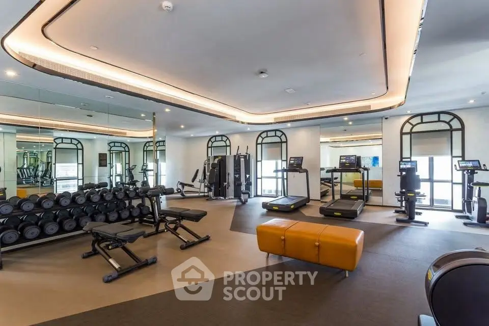Luxurious gym with modern equipment and elegant design in upscale residential building.