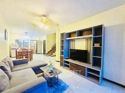 Spacious living room with modern furniture and entertainment center in a cozy home.