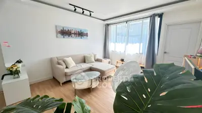 Bright and modern living room with stylish decor and large windows.