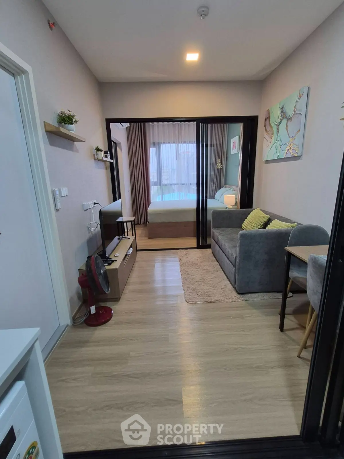 Modern compact apartment with cozy living area and bedroom, featuring stylish decor and natural light.