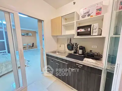Modern kitchen with sleek cabinetry and appliances in a cozy apartment setting.