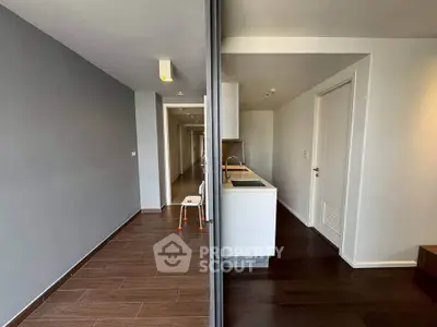 Modern apartment interior with sleek kitchen and hallway, featuring contemporary design and stylish flooring.
