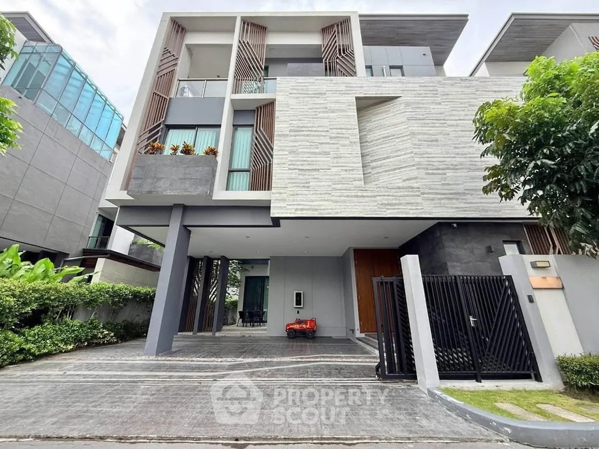 Modern multi-story house with sleek design and spacious driveway in upscale neighborhood.