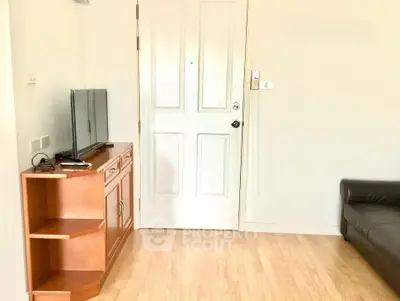 Cozy living room with wooden flooring and modern TV stand, perfect for relaxation.