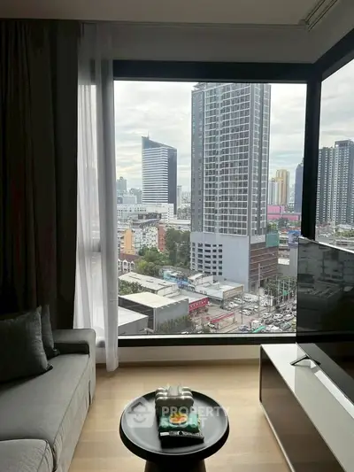 Modern living room with panoramic city view from large window, featuring stylish furniture and decor.