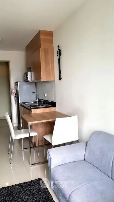 Modern compact kitchen with open layout and cozy living area in a stylish apartment.
