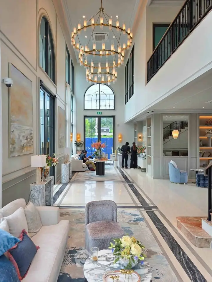 Luxurious high-ceiling lobby with elegant chandeliers and modern decor