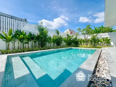 Inviting private pool with crystal-clear water, surrounded by lush greenery and modern fencing, perfect for luxurious outdoor living.