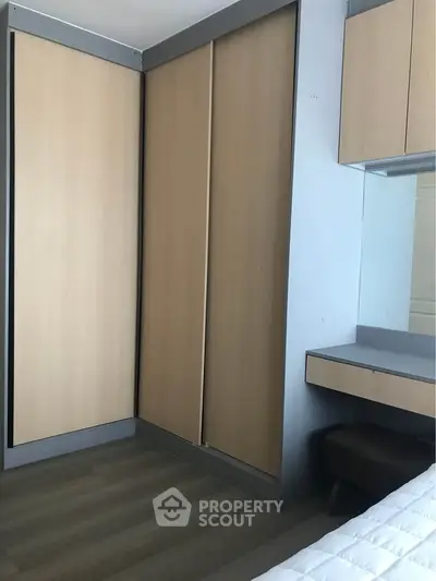 Modern bedroom with sleek wooden wardrobe and built-in desk, perfect for stylish living.