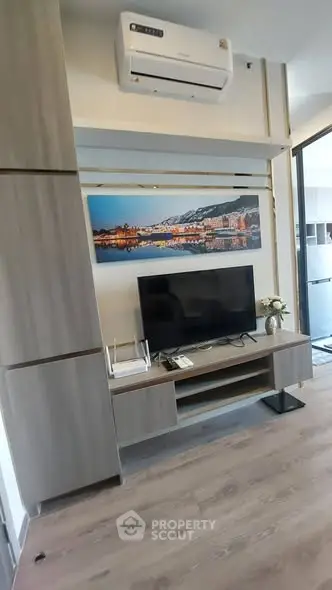 Modern living room with sleek TV unit and air conditioning, perfect for cozy entertainment.