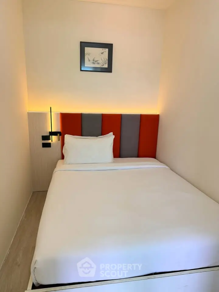 Cozy bedroom with modern lighting and stylish headboard, perfect for relaxation.