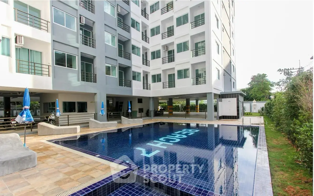 Modern apartment building with inviting pool and spacious deck area.