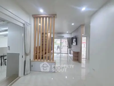 Spacious modern living room with open layout and stylish partition, perfect for contemporary living.